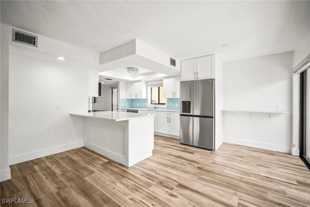 517 Lake Louise Cir Unit 101, Naples, FL 34110 - kitchen featuring stainless steel fridge, light countertops, baseboards, light wood-style floors, and white cabinets