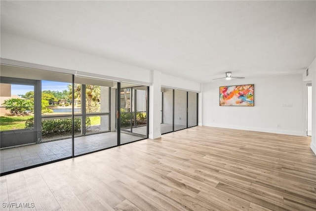 517 Lake Louise Cir Unit 101, Naples, FL 34110 - empty room with wood finished floors and a ceiling fan