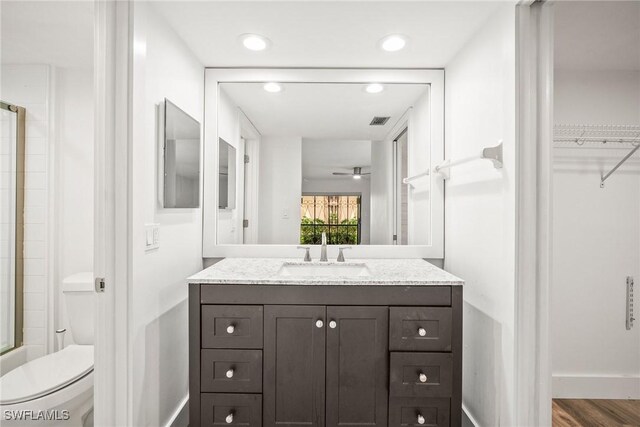 517 Lake Louise Cir Unit 101, Naples, FL 34110 - full bath with a shower with shower door, vanity, toilet, baseboards, and recessed lighting