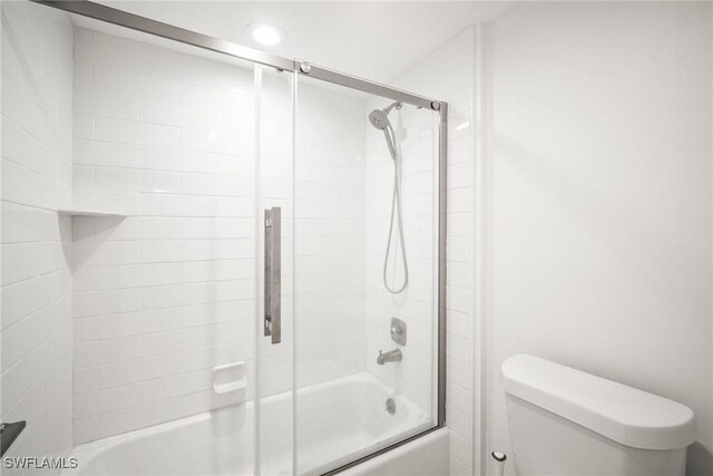 517 Lake Louise Cir Unit 101, Naples, FL 34110 - bathroom featuring bath / shower combo with glass door and toilet