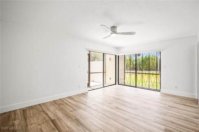 517 Lake Louise Cir Unit 101, Naples, FL 34110 - empty room with a ceiling fan, light wood-style flooring, and baseboards