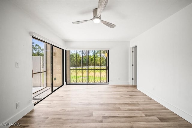 517 Lake Louise Cir Unit 101, Naples, FL 34110 - spare room featuring healthy amount of natural light, ceiling fan, wood finished floors, and baseboards