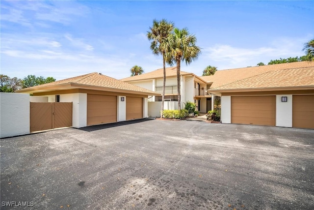 517 Lake Louise Cir Unit 101, Naples, FL 34110 - view of front of property featuring stucco siding, community garages, and a gate
