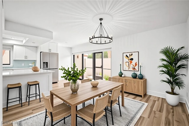 517 Lake Louise Cir Unit 101, Naples, FL 34110 - dining area featuring a chandelier, light wood finished floors, baseboards, recessed lighting, and a raised ceiling