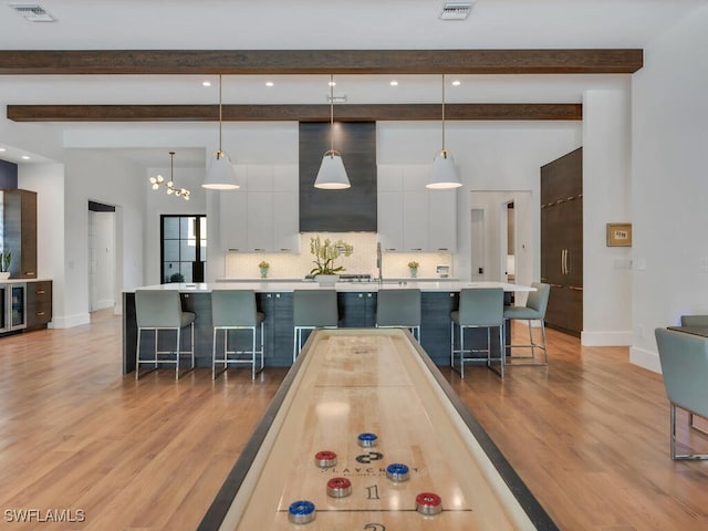 game room with light wood-type flooring, visible vents, and baseboards