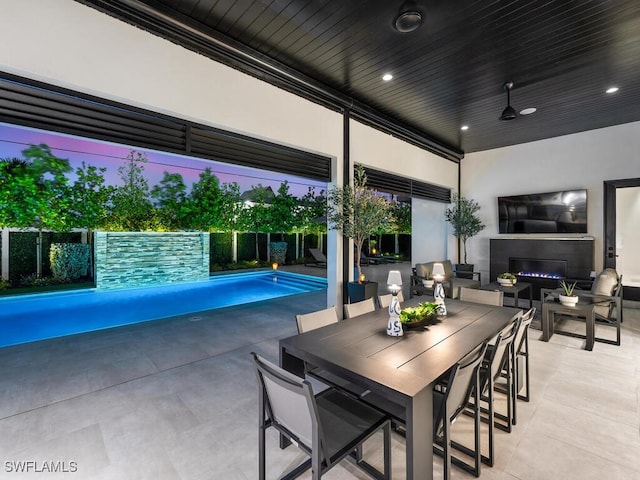 interior space with a fenced in pool, outdoor dining space, and fence