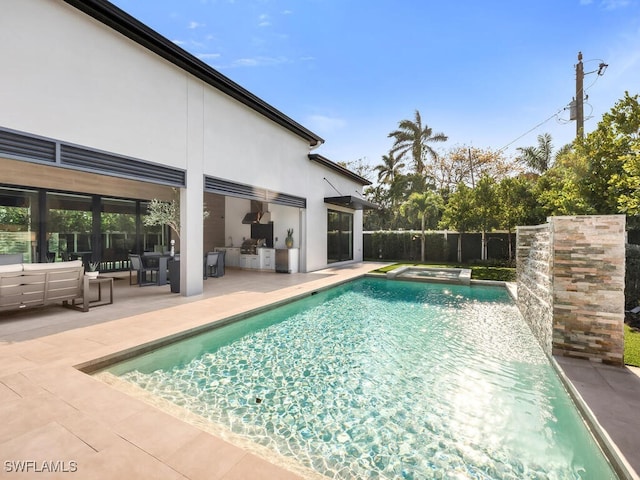 view of swimming pool featuring fence, exterior kitchen, a patio, and a fenced in pool