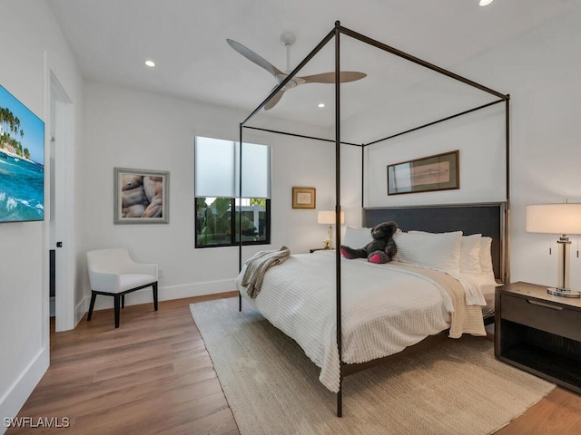 bedroom with baseboards, wood finished floors, and recessed lighting