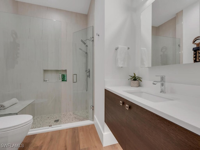 full bathroom featuring vanity, wood finished floors, a shower stall, and toilet