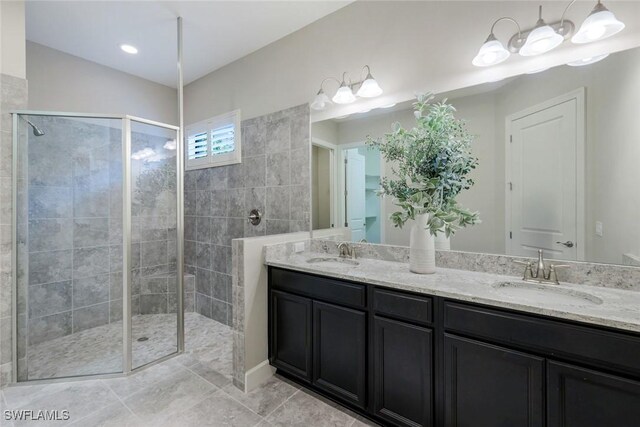 bathroom featuring double vanity, a shower stall, and a sink