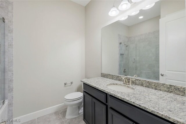 bathroom with tile patterned flooring, vanity, toilet, and tiled shower