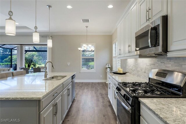 kitchen featuring plenty of natural light, visible vents, appliances with stainless steel finishes, a sink, and baseboards