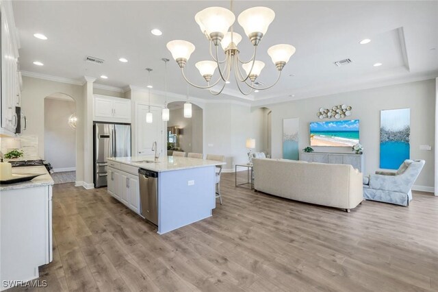 kitchen featuring visible vents, arched walkways, a sink, and appliances with stainless steel finishes
