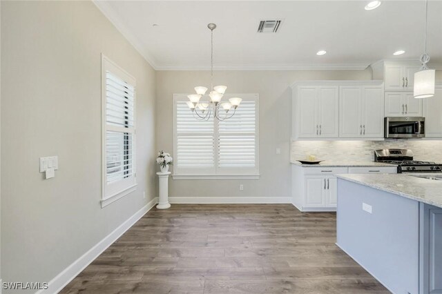 kitchen with visible vents, an inviting chandelier, wood finished floors, white cabinets, and stainless steel appliances