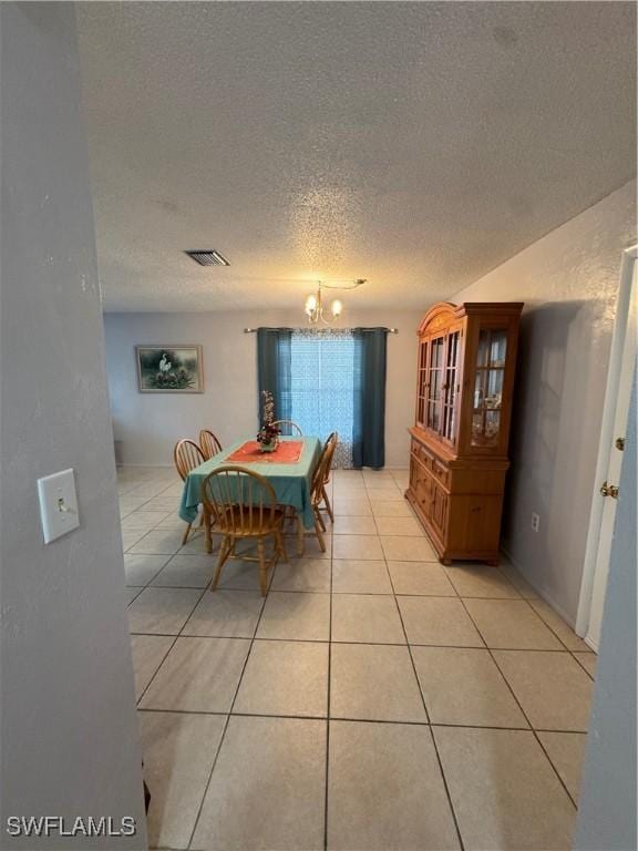 dining space with a chandelier, visible vents, light tile patterned floors, and a textured ceiling