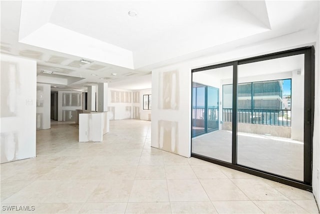 26130 Hickory Blvd Unit 1B, Bonita Springs, FL 34134 - empty room featuring light tile patterned floors and a raised ceiling