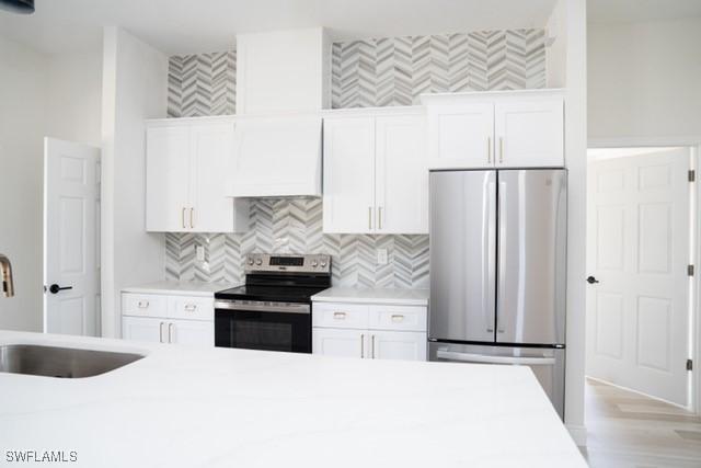 1194 Calico St, Labelle, FL 33935 - kitchen featuring white cabinets, stainless steel appliances, a sink, custom exhaust hood, and light countertops