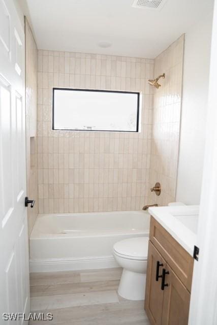 1194 Calico St, Labelle, FL 33935 - full bathroom with wood finished floors, vanity, tub / shower combination, toilet, and visible vents