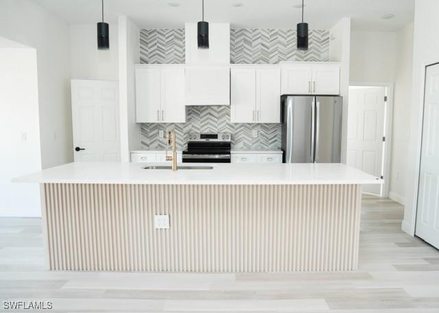 1194 Calico St, Labelle, FL 33935 - kitchen with light countertops, a sink, an island with sink, and appliances with stainless steel finishes