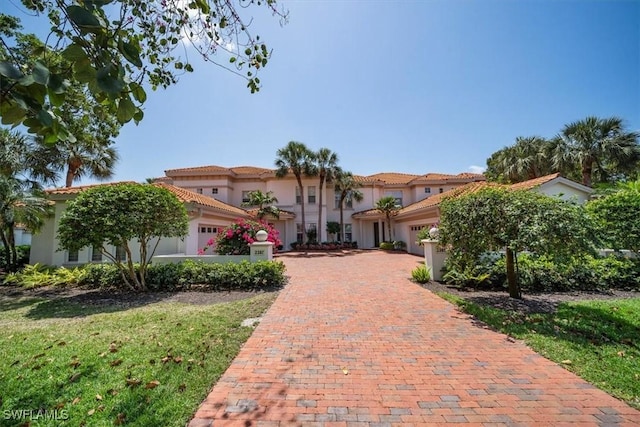 2387 Terra Verde Ln Unit 2387, Naples, FL 34105 - mediterranean / spanish-style home with stucco siding, a tiled roof, and a garage
