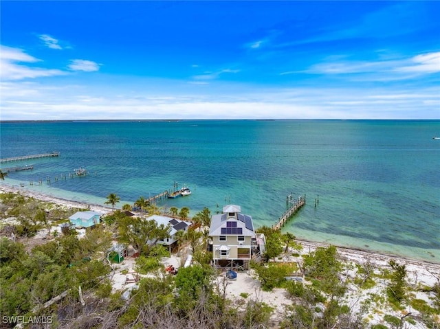 birds eye view of property featuring a water view and a beach view