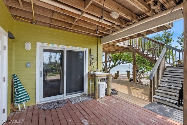 wooden deck featuring stairs and a water view