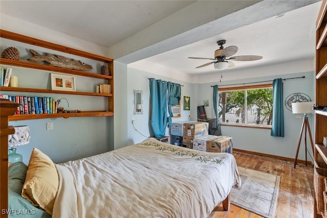 bedroom featuring wood-type flooring, baseboards, and ceiling fan