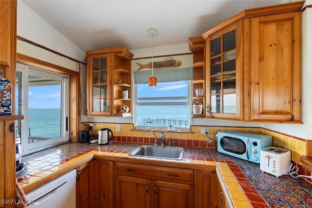 kitchen with open shelves, a sink, dishwasher, brown cabinetry, and glass insert cabinets