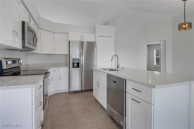 3340 33rd Ave NE, Naples, FL 34120 - kitchen featuring white cabinets, stainless steel appliances, a sink, light countertops, and hanging light fixtures
