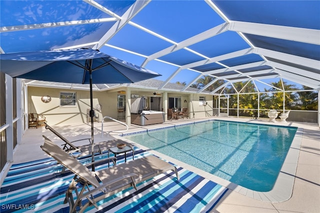 outdoor pool with a lanai, a ceiling fan, a patio area, and a hot tub