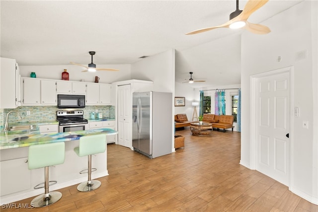 kitchen with decorative backsplash, appliances with stainless steel finishes, ceiling fan, a sink, and a peninsula