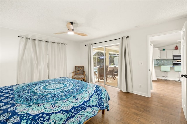 bedroom featuring a textured ceiling, wood finished floors, ceiling fan, and access to exterior
