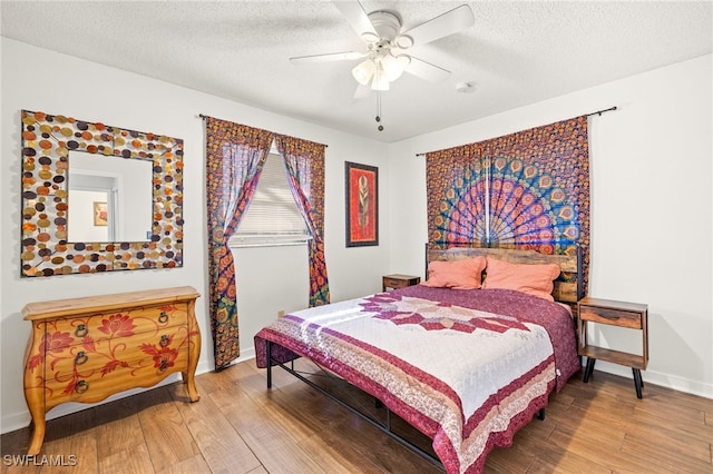 bedroom featuring a textured ceiling, ceiling fan, wood finished floors, and baseboards