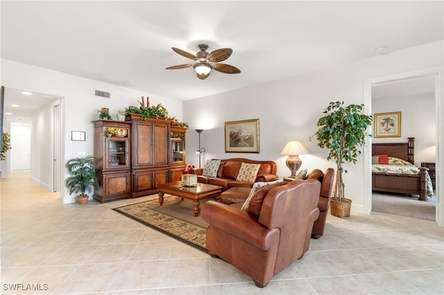living room featuring visible vents, baseboards, ceiling fan, and light tile patterned floors
