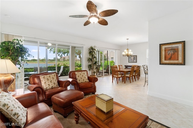 living room featuring baseboards, a water view, ceiling fan with notable chandelier, and light tile patterned flooring