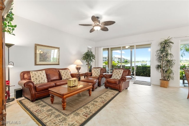 living area featuring baseboards, ceiling fan, and light tile patterned flooring