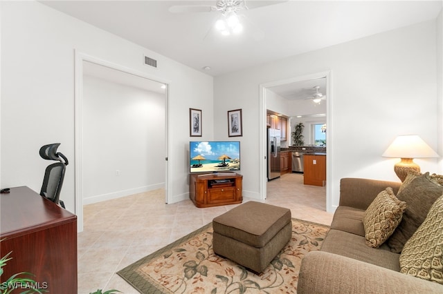 living room with light tile patterned floors, baseboards, ceiling fan, and visible vents