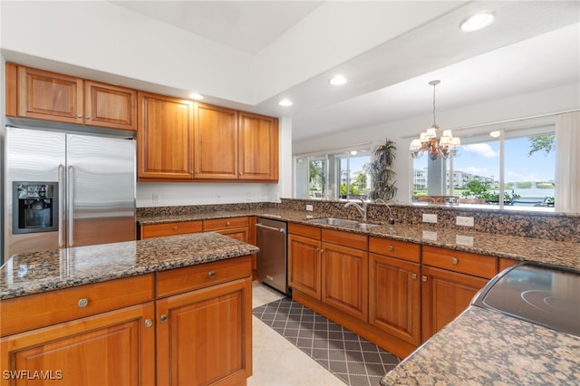 kitchen with brown cabinets, recessed lighting, appliances with stainless steel finishes, and a sink