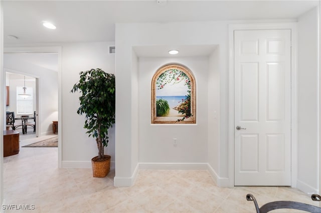 hallway with light tile patterned floors, baseboards, recessed lighting, and visible vents