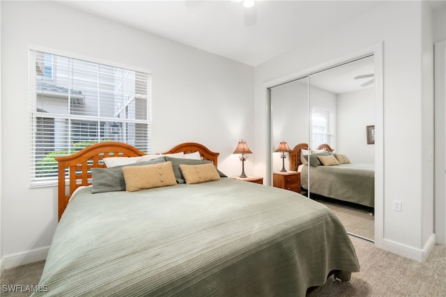 carpeted bedroom with baseboards, ceiling fan, and a closet