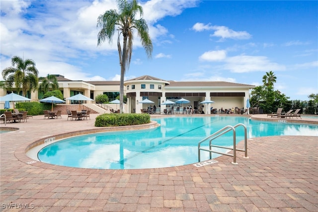 pool with a patio and outdoor dining space