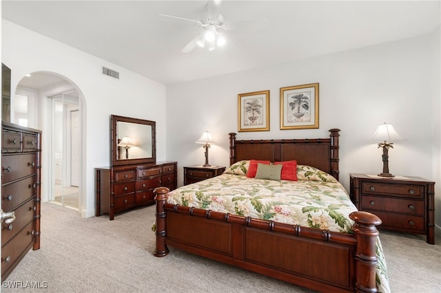 bedroom with ceiling fan, visible vents, arched walkways, baseboards, and light carpet