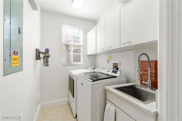 laundry area featuring cabinet space, independent washer and dryer, a sink, baseboards, and light tile patterned floors