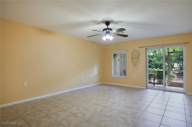 spare room featuring light tile patterned floors, ceiling fan, and baseboards