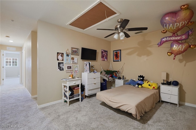 carpeted bedroom with attic access, ceiling fan, and baseboards