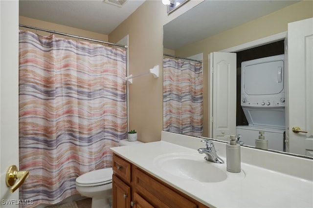 full bath with stacked washing machine and dryer, vanity, and toilet