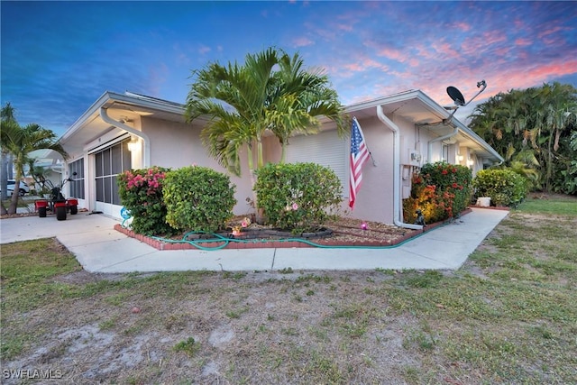 534 Bethany Village Cir, Lehigh Acres, FL 33936 - property exterior at dusk featuring stucco siding