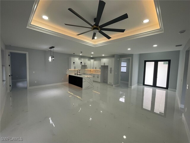 2710 10th St SW, Lehigh Acres, FL 33976 - unfurnished living room with a raised ceiling, recessed lighting, a sink, ceiling fan, and baseboards