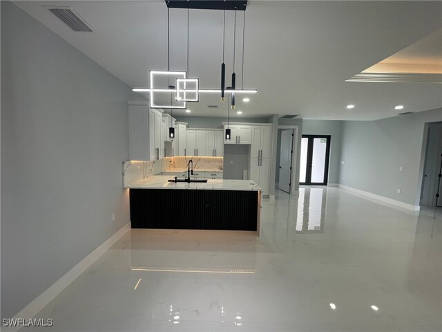 2710 10th St SW, Lehigh Acres, FL 33976 - kitchen featuring a sink, white cabinets, recessed lighting, baseboards, and hanging light fixtures