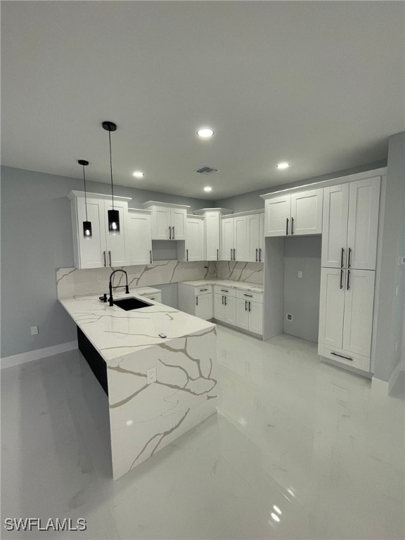 2710 10th St SW, Lehigh Acres, FL 33976 - kitchen with a sink, baseboards, light stone counters, a peninsula, and recessed lighting